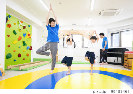 室内で運動をする子供たちと先生 広角	 99485462