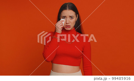 Upset disappointed woman wipes tears and cries from despair being sad because of unfair things Upset disappointed woman wipes tears and cries from despair being sad because of unfair things 99485916