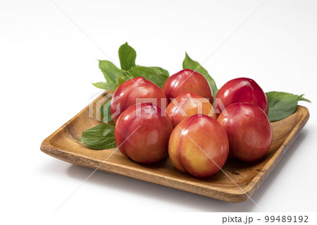 白バックで木皿に並べたすもも 99489192