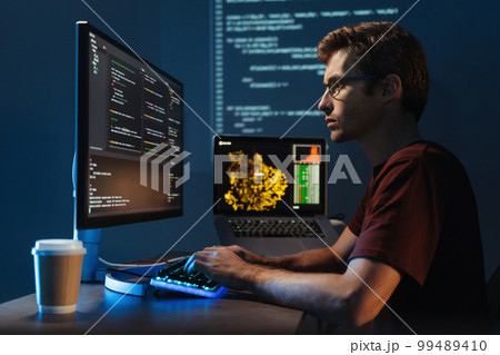 Young it specialist working at pc at home, debugging java script cyber space error Young it specialist working at pc at home, debugging java script cyber space error 99489410