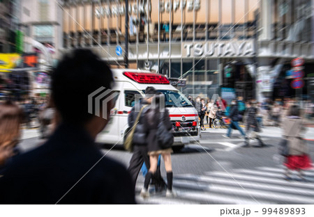 日本の東京都市景観　救急車が交差点にさしかかっても平気な顔をして渡ろうとする歩行者の姿も。マイクで… 99489893