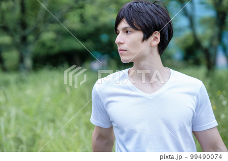 新緑の公園を満喫するハーフの男性 99490074