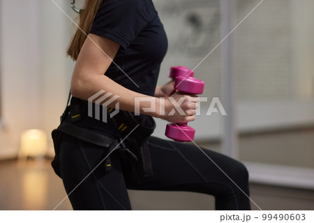 Bungee fitness. Training on loops. A beautiful sports woman trains in the gym with the help of special loops. 99490603