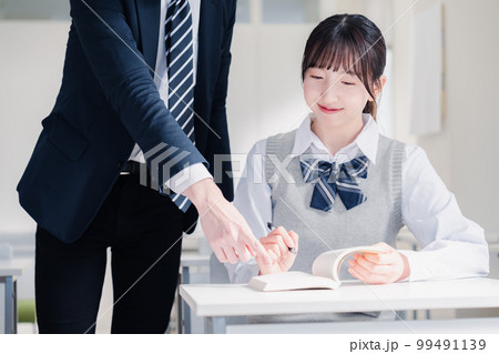 教室で先生に質問をする女子高生 教室で先生に質問をする女子高生 99491139