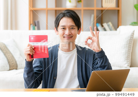 通帳を見て喜ぶミドル男性　OK 99491449