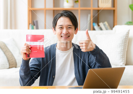 通帳を見て喜ぶミドル男性　サムズアップ 99491455