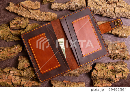 Open brown mens wallet with money and credit cards 99492564