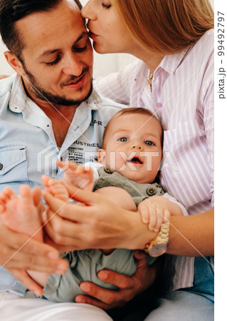 Young happy family. Careful young caucasian parents with their little cute baby boy.  99492797