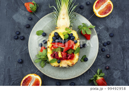 Fruit salad in half a pineapple. 99492958