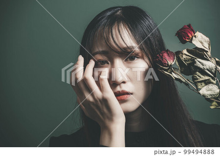 ドライフラワーをとグリーンバックと黒いワンピースの女性 99494888