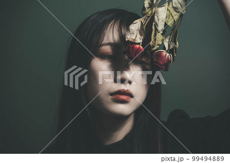 ドライフラワーをとグリーンバックと黒いワンピースの女性 99494889