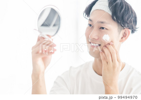 顔に洗顔フォームを塗る若い男性 99494970