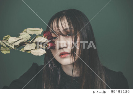 グリーンバックとバラを持った黒いワンピースの女性 グリーンバックとバラを持った黒いワンピースの女性 99495186