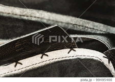 Hand made sewing stitch of leather handbag, coarse thread on leather texture. Concept of manufacture Hand made sewing stitch of leather handbag, coarse thread on leather texture. Concept of manufacture 99495400