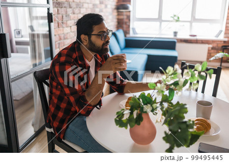 Couple drinking a morning coffee together. Man talks with her wife - lifestyle and communication family concept Couple drinking a morning coffee together. Man talks with her wife - lifestyle and communication family concept 99495445
