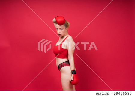 Boxer, seductive confident female boxer with gloves studio, sporty woman posing looking at camera. 99496586
