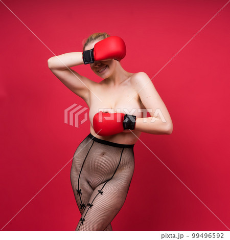 Boxer, seductive confident female boxer with gloves studio, sporty woman posing looking at camera. 99496592