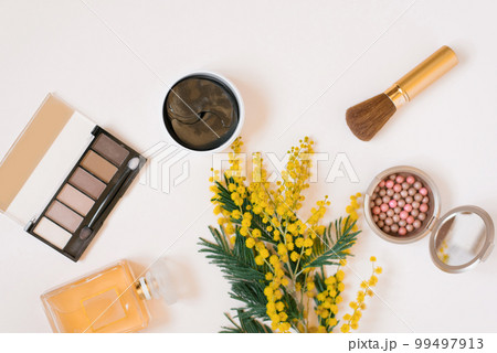 Flat lay fashion blogger. Decorative cosmetics and perfume and a branch of yellow mimosa flowers on a white background Flat lay fashion blogger. Decorative cosmetics and perfume and a branch of yellow mimosa flowers on a white background 99497913