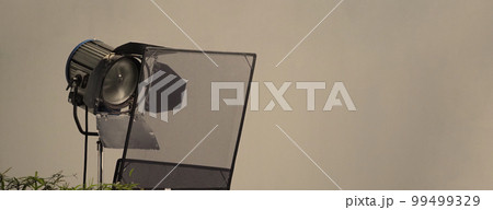 Film light for video production camera in studio set. Use as studio photo shoot light. Big LED spot light 5000w and diffuser or black panel create light like sun light can make daytime or golden hour Film light for video production camera in studio set. Use as studio photo shoot light. Big LED spot light 5000w and diffuser or black panel create light like sun light can make daytime or golden hour 99499329