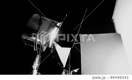 Film light for video production camera in studio set. Use as studio photo shoot light. Big LED spot light 5000w and diffuser or black panel create light like sun light can make daytime or golden hour Film light for video production camera in studio set. Use as studio photo shoot light. Big LED spot light 5000w and diffuser or black panel create light like sun light can make daytime or golden hour 99499343