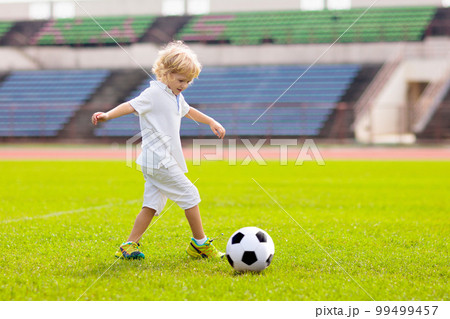 Kids play football. Child at soccer field. Kids play football. Child at soccer field. 99499457