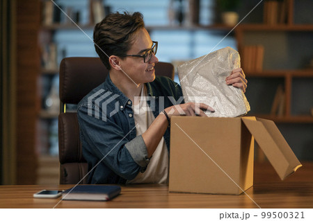 Happy young man customer got brand new laptop computer, office interior 99500321