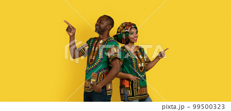 Positive happy black man and woman pointing at copy space 99500323