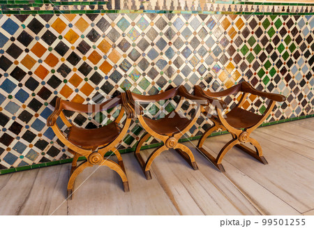 Old wooden chairs with skin (restored) at  Myrtle courtyard - Moorish art in the Alhambra  museum complex  in  Granada 99501255