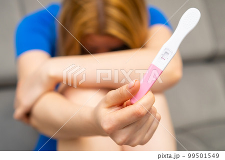 Upset woman holding a negative pregnancy test. Strong wish to have a baby and infertility Upset woman holding a negative pregnancy test. Strong wish to have a baby and infertility 99501549