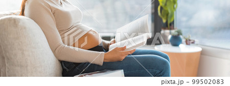 Pregnant woman reading prenatal books preparing for labor, birth, newborn and motherhood sitting on sofa at home. Pregnancy lifestyle panoramic banner Pregnant woman reading prenatal books preparing for labor, birth, newborn and motherhood sitting on sofa at home. Pregnancy lifestyle panoramic banner 99502083