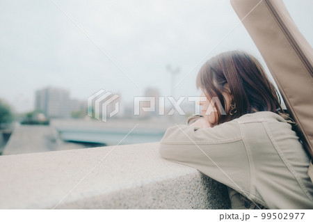 橋で佇むギターを持った女性の写真 99502977