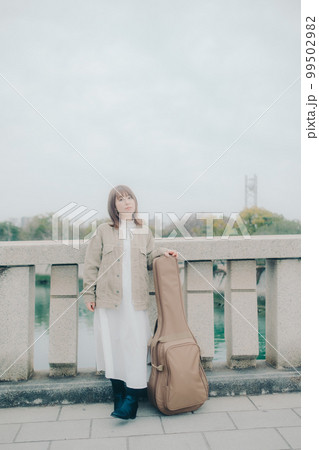 橋で佇むギターを持った女性の写真 橋で佇むギターを持った女性の写真 99502982