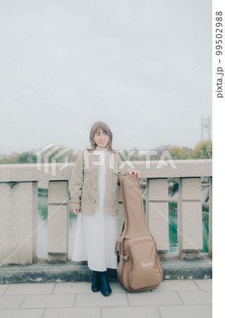 橋で佇むギターを持った女性の写真 橋で佇むギターを持った女性の写真 99502988