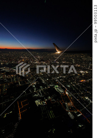 飛行機の窓の外から観る夕焼けと富士山と東京の夜景 99503113