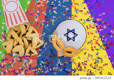 It is Jewish festival that is celebration with cookies, shofars, tallits, carnival masks, and hamantaschen symbols to celebrate Purim It is Jewish festival that is celebration with cookies, shofars, tallits, carnival masks, and hamantaschen symbols to celebrate Purim 99503224