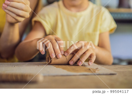 mother and son doing ceramic pot in pottery workshop 99504117