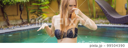 Young woman with disgust on his face pinches nose, something stinks, very bad smell in swimming pool because of pool chemicals. Negative emotion facial expression BANNER, LONG FORMAT Young woman with disgust on his face pinches nose, something stinks, very bad smell in swimming pool because of pool chemicals. Negative emotion facial expression BANNER, LONG FORMAT 99504390