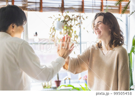 仲良しのカップル　ハイタッチ 99505458