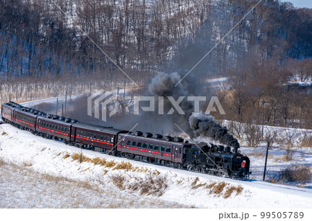 黒煙をあげながらコーナーをまわるSL冬の湿原号 99505789