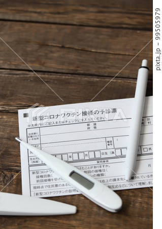 新型コロナワクチンの予診票と体温計とボールペン 99505979