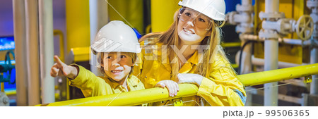Young woman and a little boy are both in a yellow work uniform, glasses, and helmet in an industrial environment, oil Platform or liquefied gas plant BANNER, LONG FORMAT Young woman and a little boy are both in a yellow work uniform, glasses, and helmet in an industrial environment, oil Platform or liquefied gas plant BANNER, LONG FORMAT 99506365