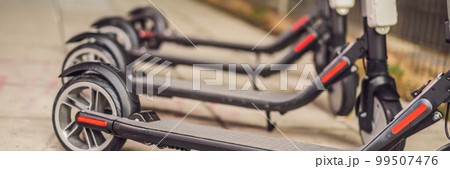 Electric scooters for rent. urban transport. Electric Ride Sharing Scooters Lined Up and Ready to Rent BANNER, LONG FORMAT 99507476