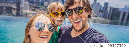 Vacation and technology. Happy family with kid taking selfie together near swimming pool with panoramic views of the city BANNER, LONG FORMAT Vacation and technology. Happy family with kid taking selfie together near swimming pool with panoramic views of the city BANNER, LONG FORMAT 99507500