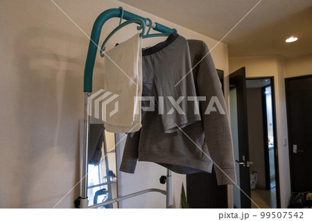 部屋に置いた、ぶら下がり健康器に下げた洗濯物 99507542