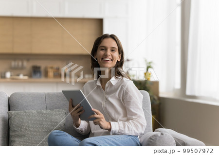 Happy pretty young tablet user woman home portrait 99507972