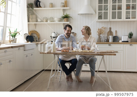 Happy married couple baking together, cooking pastry food 99507975