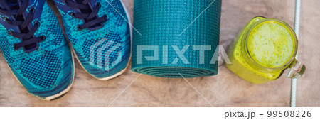 BANNER, LONG FORMAT Everything for sports turquoise, blue shades on a wooden background and spinach smoothies. Yoga mat, sport shoes sportswear and bottle of water. Concept healthy lifestyle, sport 99508226