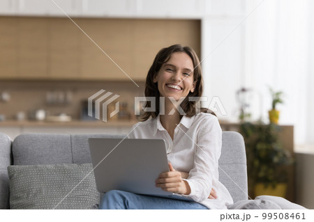 Happy freelance business woman holding laptop, sitting on couch Happy freelance business woman holding laptop, sitting on couch 99508461