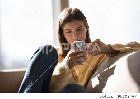 Relaxed positive millennial cellphone user girl using online application 99508467