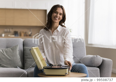 Portrait of happy hipster girl using old phonograph 99508737